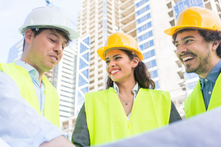 Architects and civil engineers with ground plot on construction site of highrise building